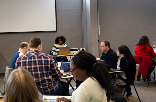 A crowd of people sat down in a conference room listening to a speaker.