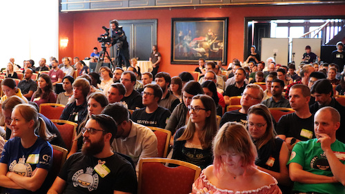 A crowd of people sat down in a conference room listening to a speaker.