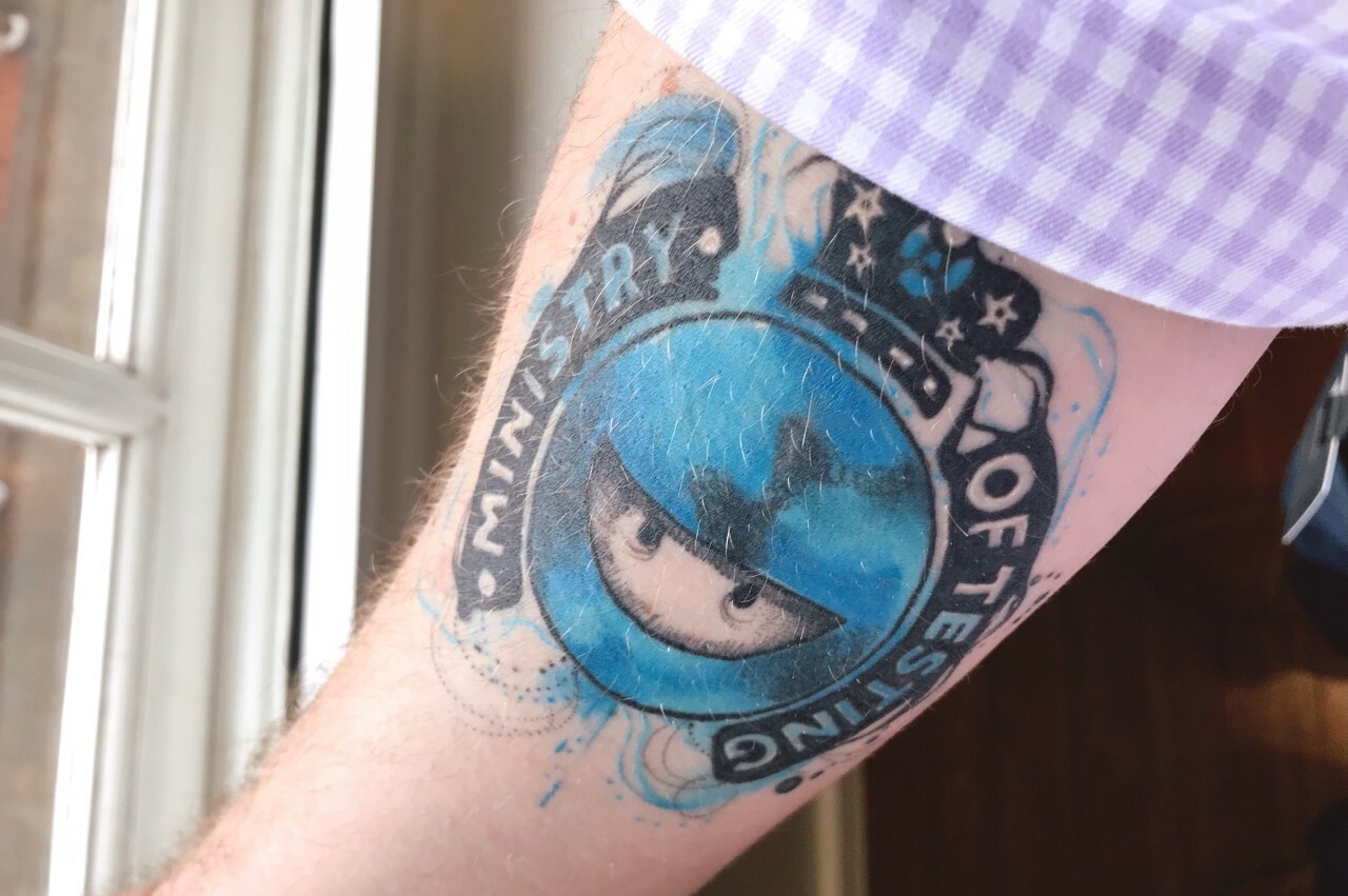 A photo of an arm with a Ministry of Testing logo tattoo