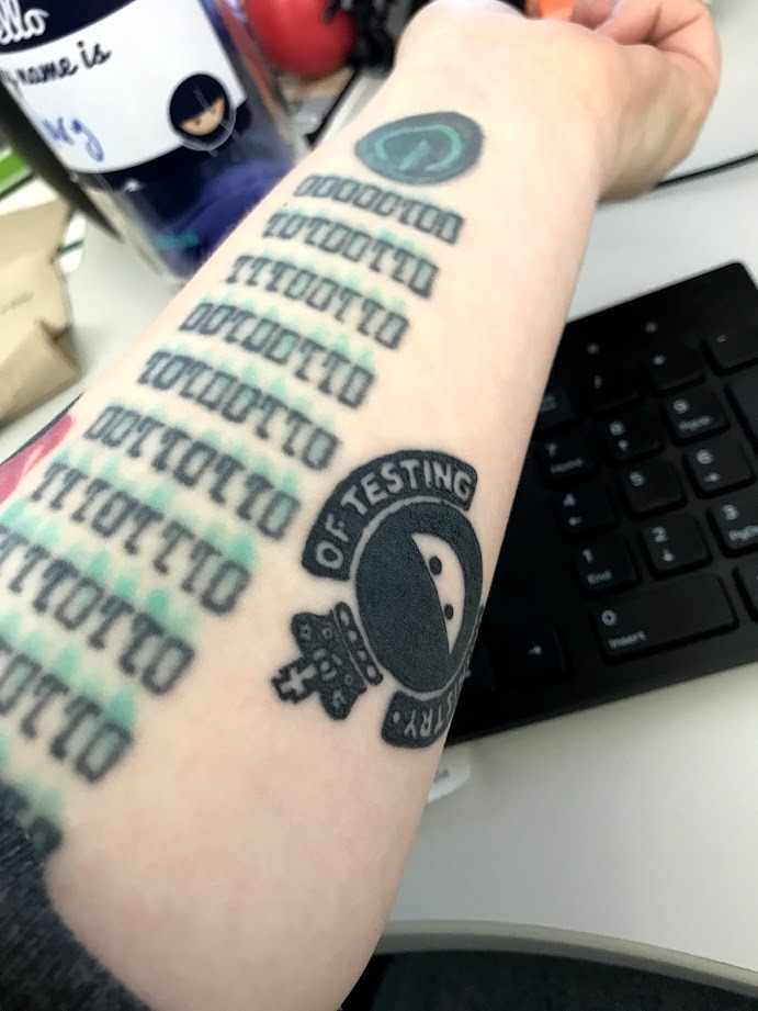 Photo of an arm with a Ministry of Testing logo tattoo